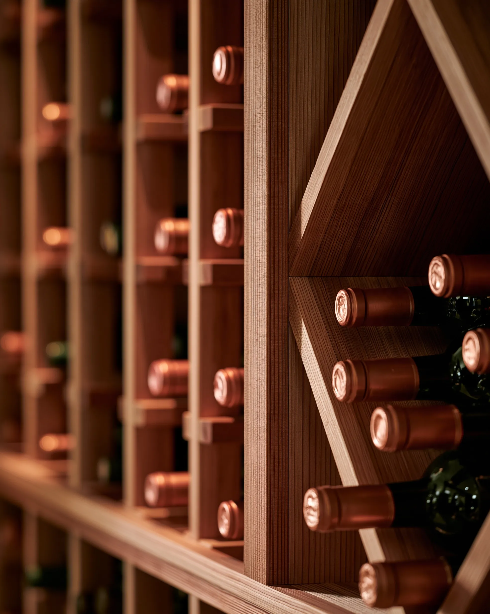Close view of light wood individual bottle slots beside a diamond bin with bottles stacked neck-out